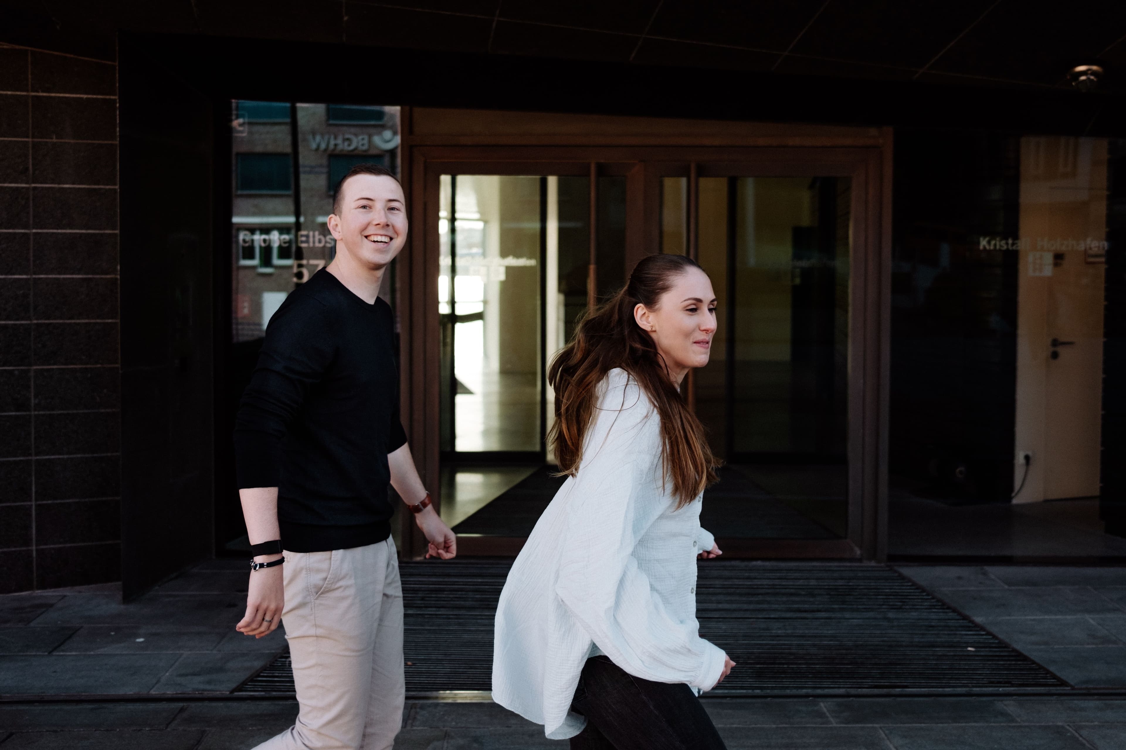Yase und Lukas laufen lachend am Hafen.
