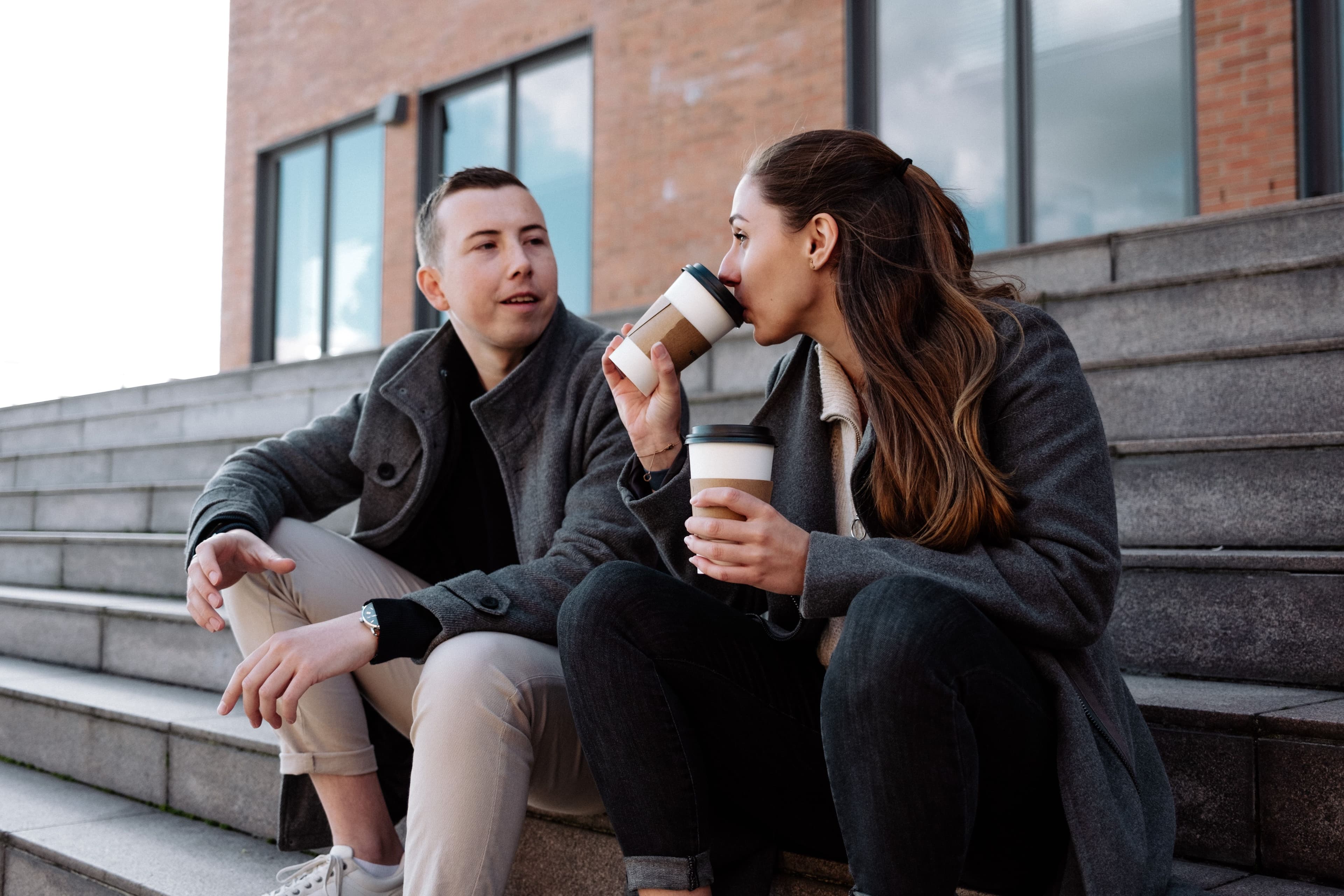 Lukas schaut Yase an, während sie seinen Kaffee probiert.
