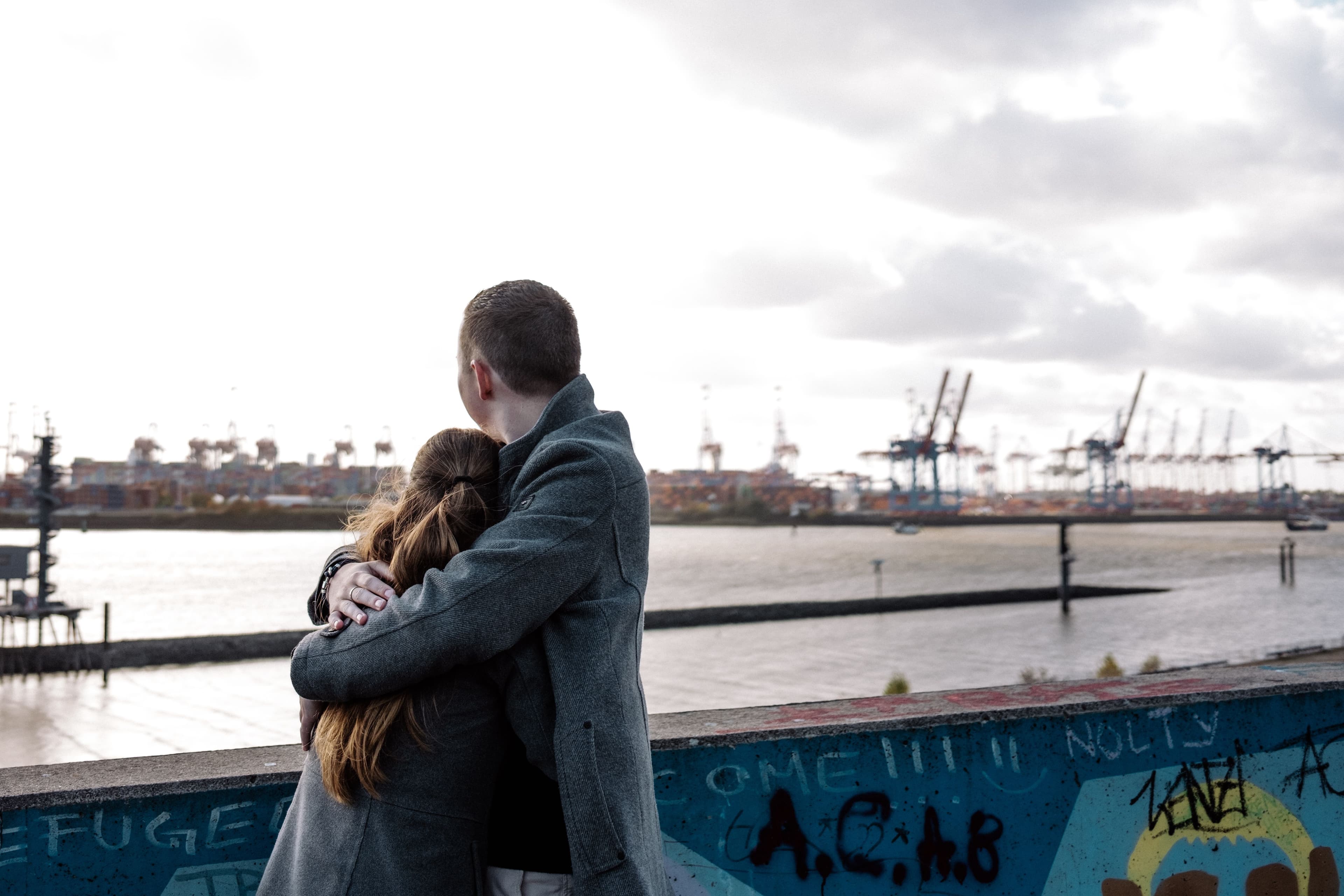 Lukas hat Yase im Arm und sie schauen auf den Hamburger Hafen.